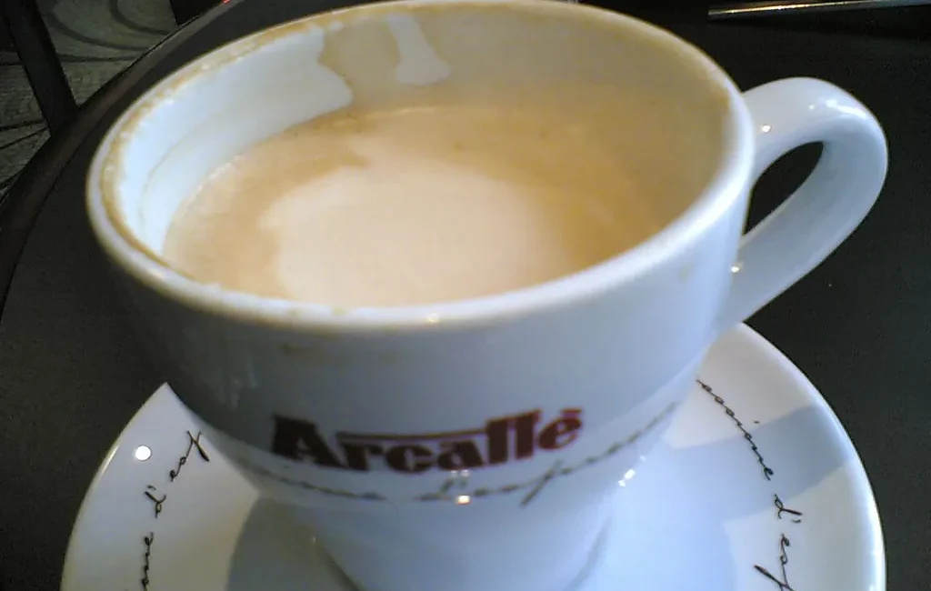 Latte in a white cup and saucer