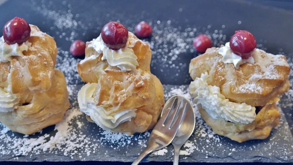Cream puffs filled with cream and topped with cherries