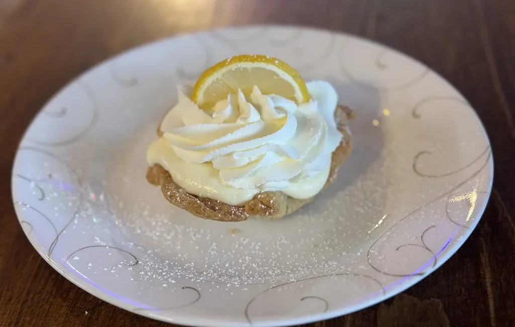 Slice of lemon pie topped with whipped cream