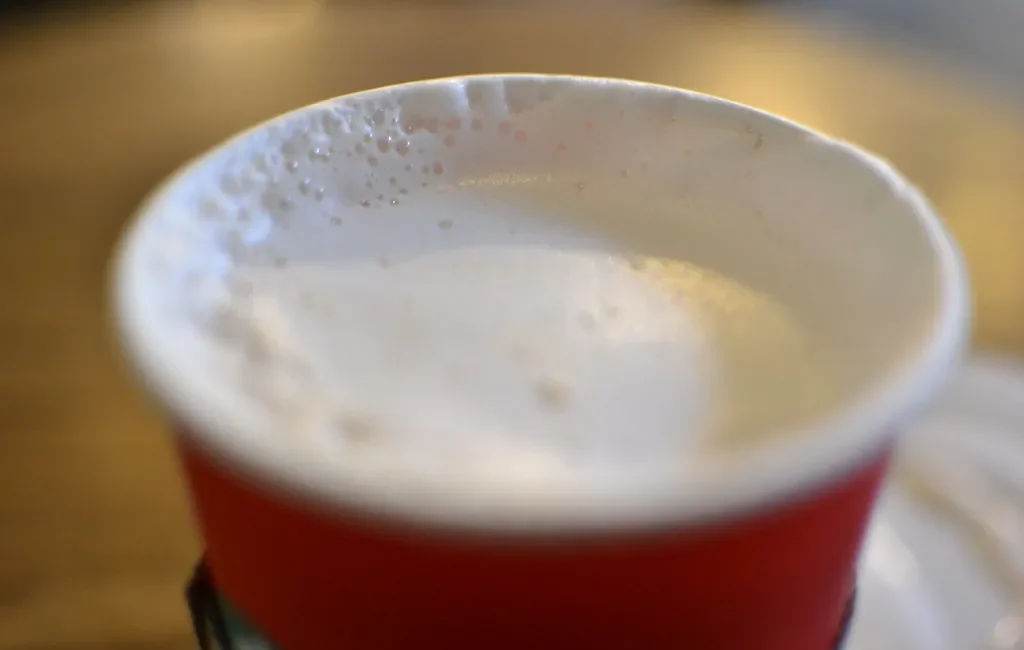 Frothy tea latte in a red cup