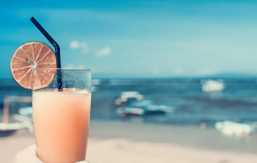 Cold orange drink with an orange slice and a straw