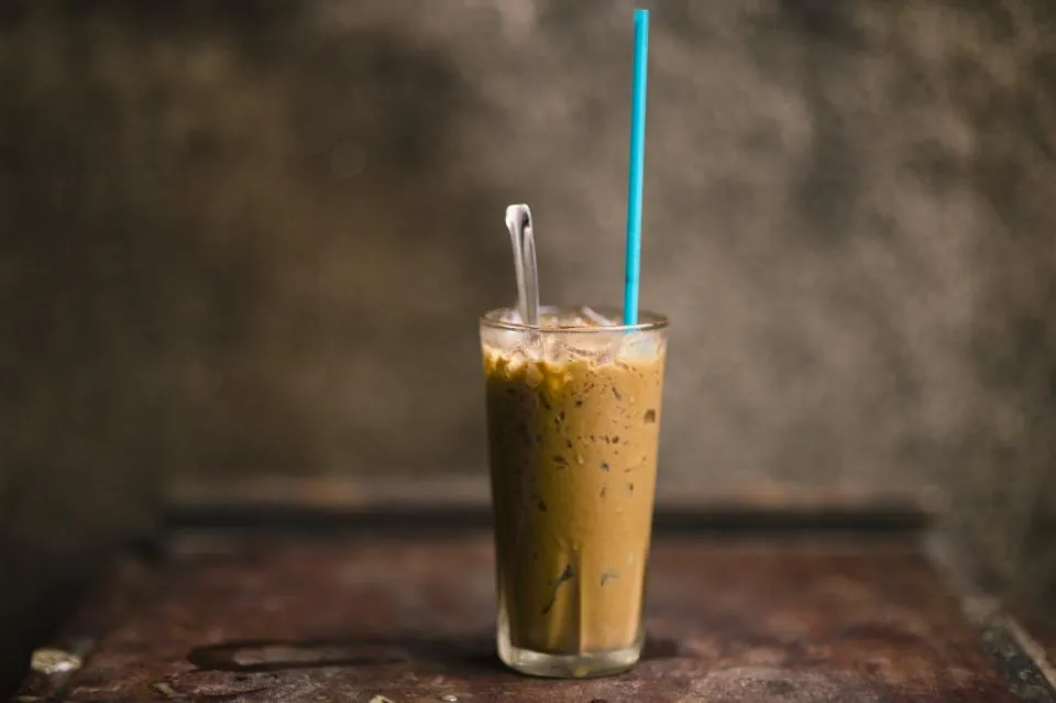 Iced coffee in a tall glass with a straw