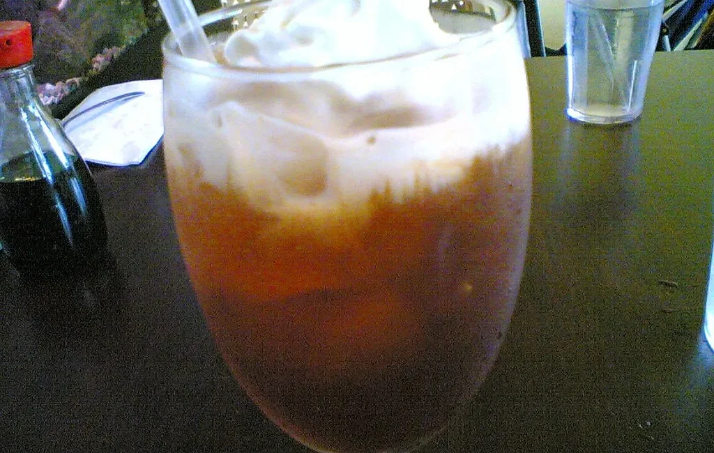 Thai iced tea with a cream top in a tall glass